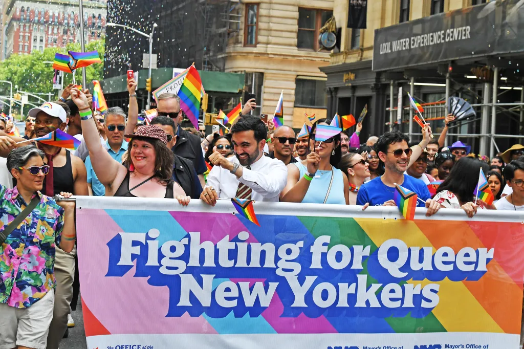 A group of people, including NYC Mayor Zohran Mamdani, carry a banner that reads 