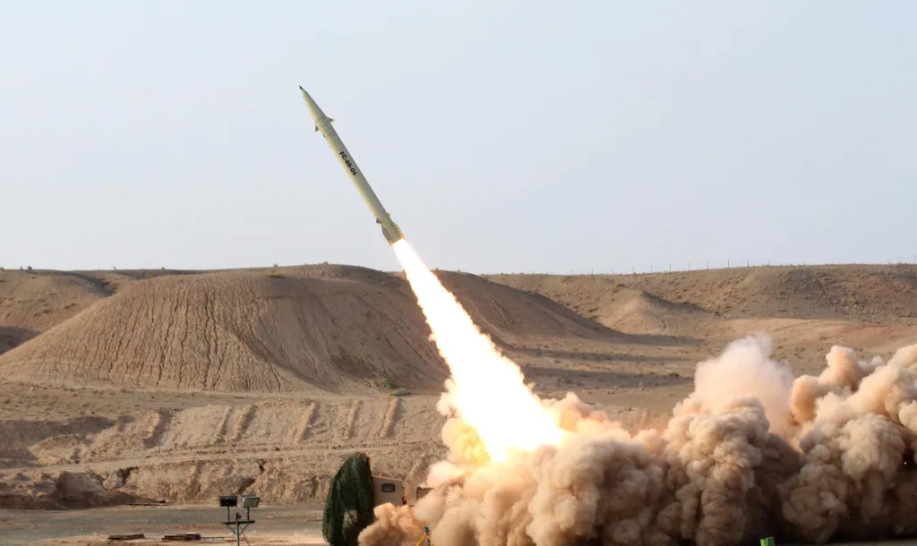 Iran's Fateh 110 surface-to-surface missile taking off with a large plume of smoke and fire.