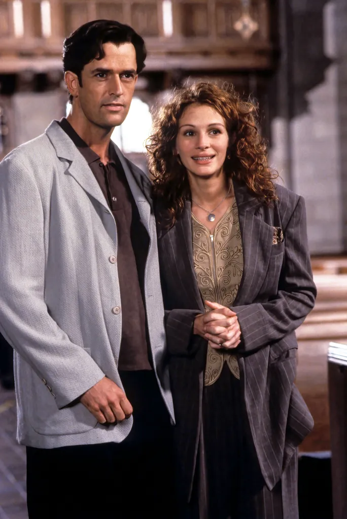 Rupert Everett and Julia Roberts standing together indoors.