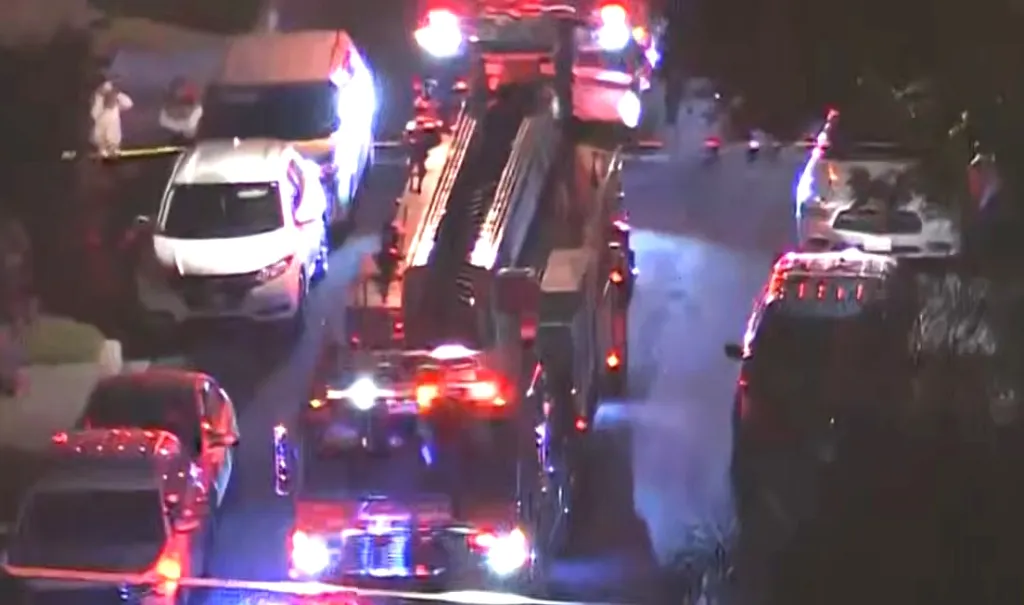 Overhead view of a fire truck and police vehicles at an emergency scene at night.