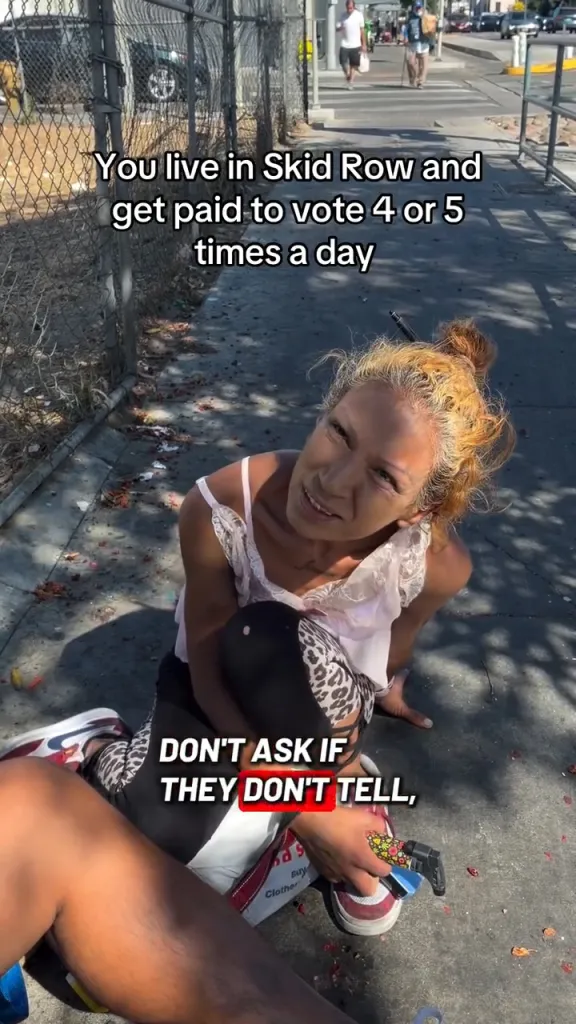 A woman on Skid Row looks up at the camera while text on the image reads,