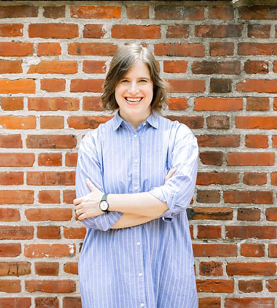 A woman leaning up against a brick wall.