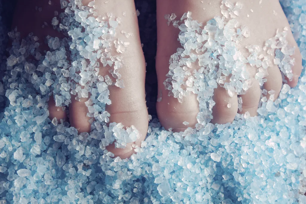 Feet partially submerged in blue bath salts.