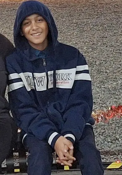 A young boy in a dark blue hooded jacket with 