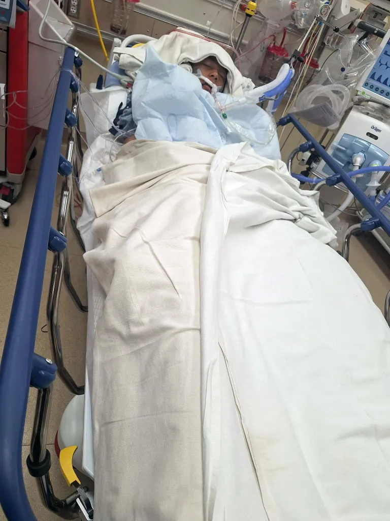 A child in a hospital bed with medical equipment.
