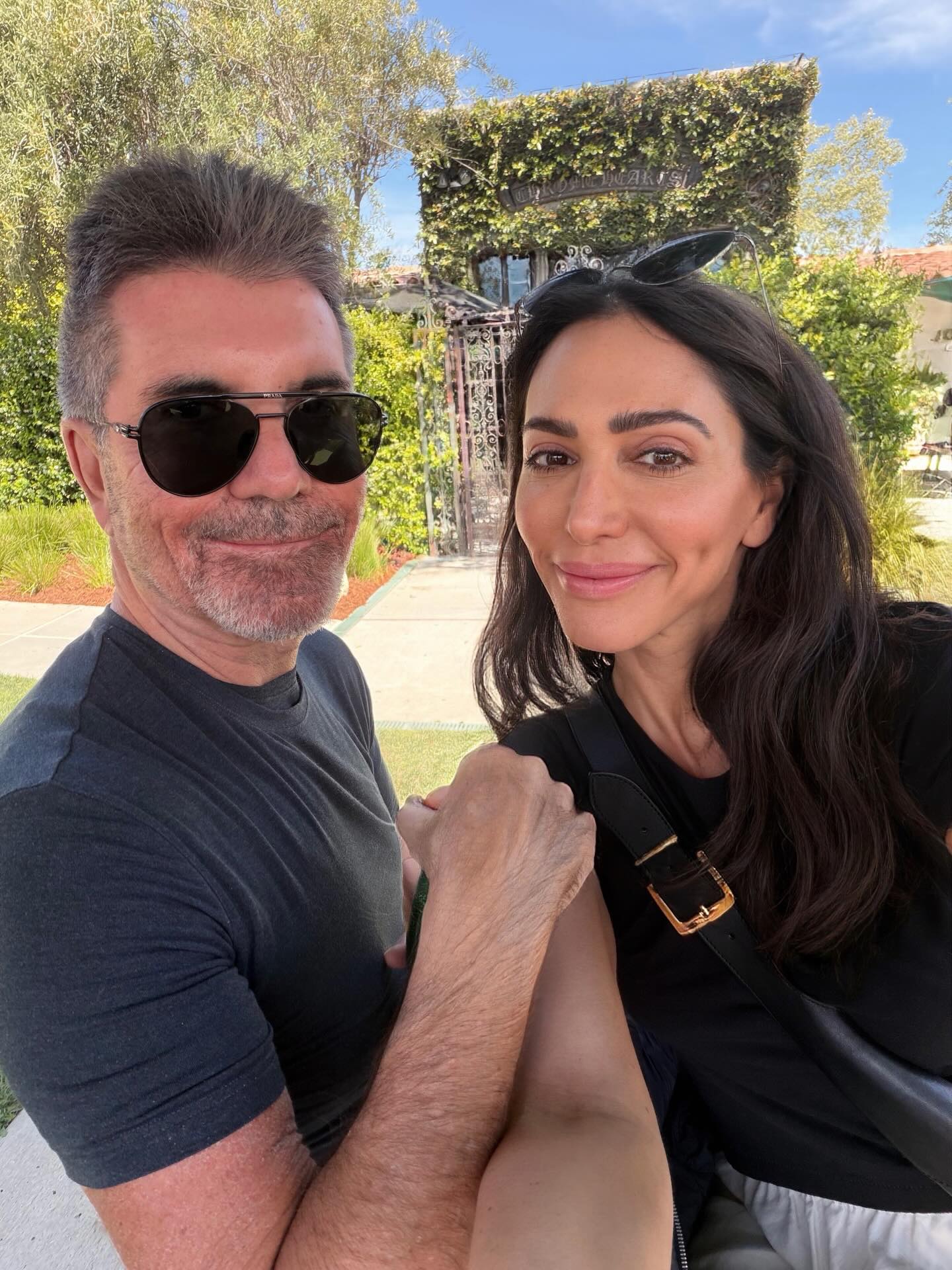 Simon Cowell and Lauren Silverman pose together outdoors.