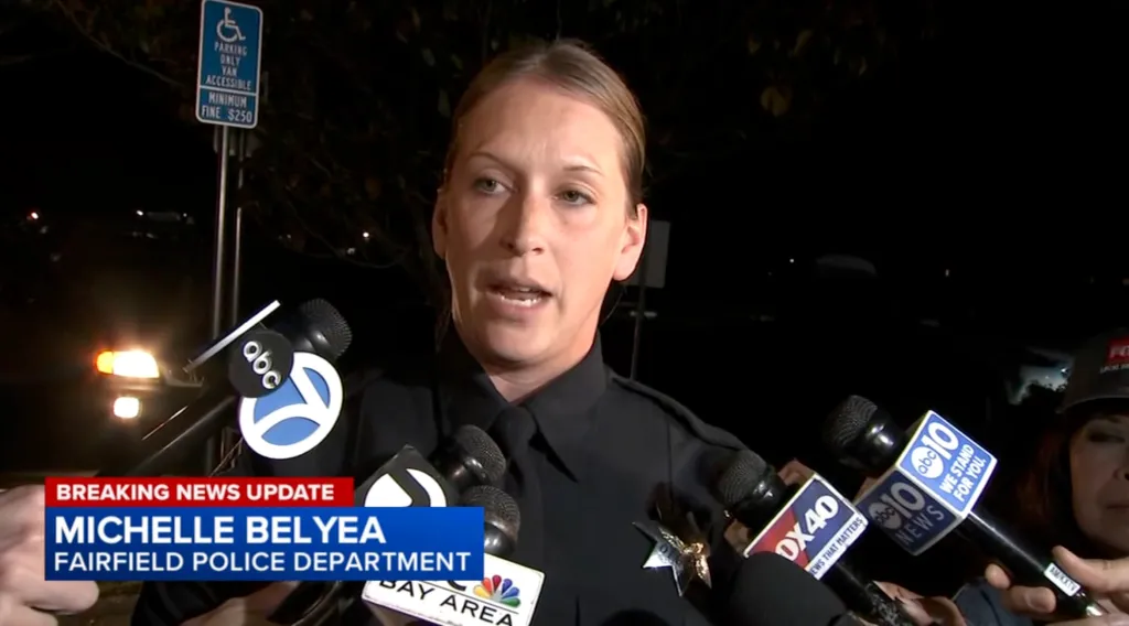 Michelle Belyea of the Fairfield Police Department speaks to reporters at night.