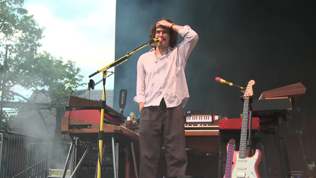 Peter Anspach pays tribute to Paul Kuerker during Goose's concert in Central Park on Sunday night.