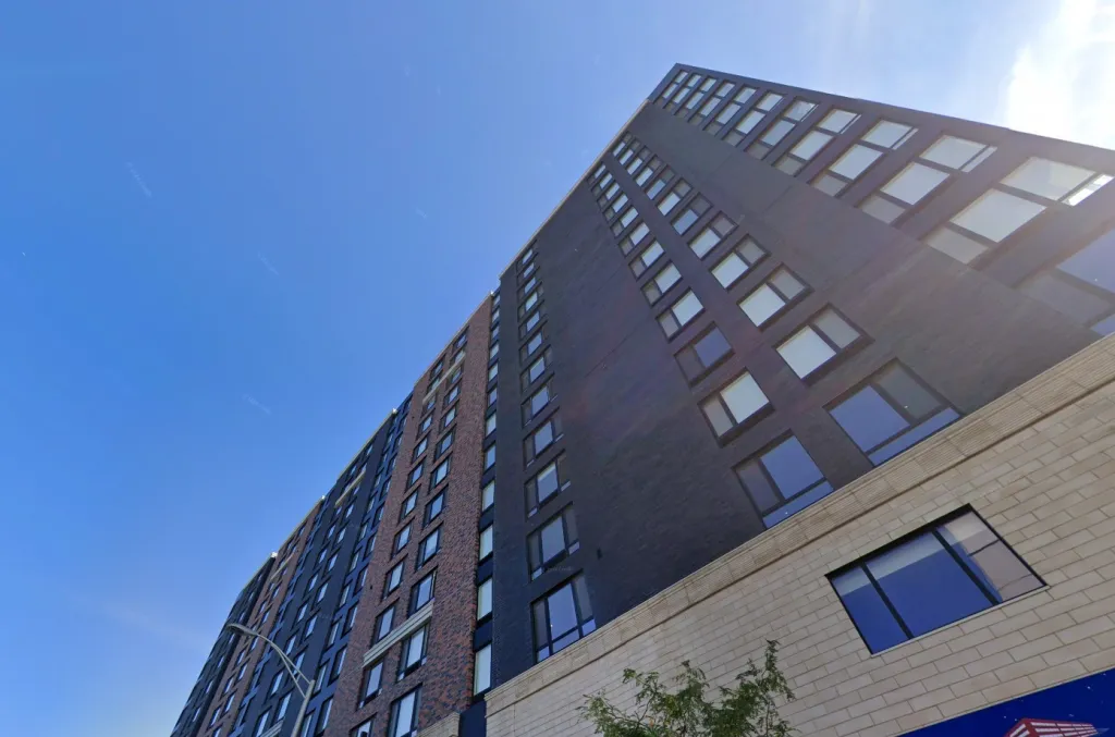 Exterior of 150 Main Street Hackensack, NJ, a tall building with dark and brick-colored facades, viewed from a low angle.