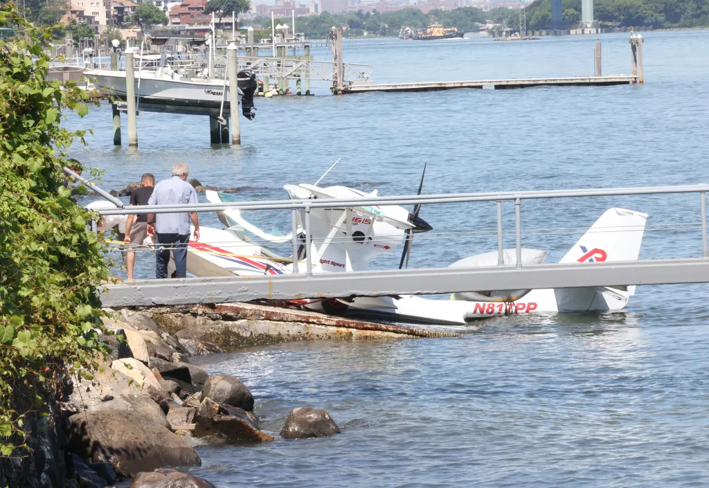 Giuseppe Oppedisano and another passenger towing his crashed two-passenger aircraft up to his property.