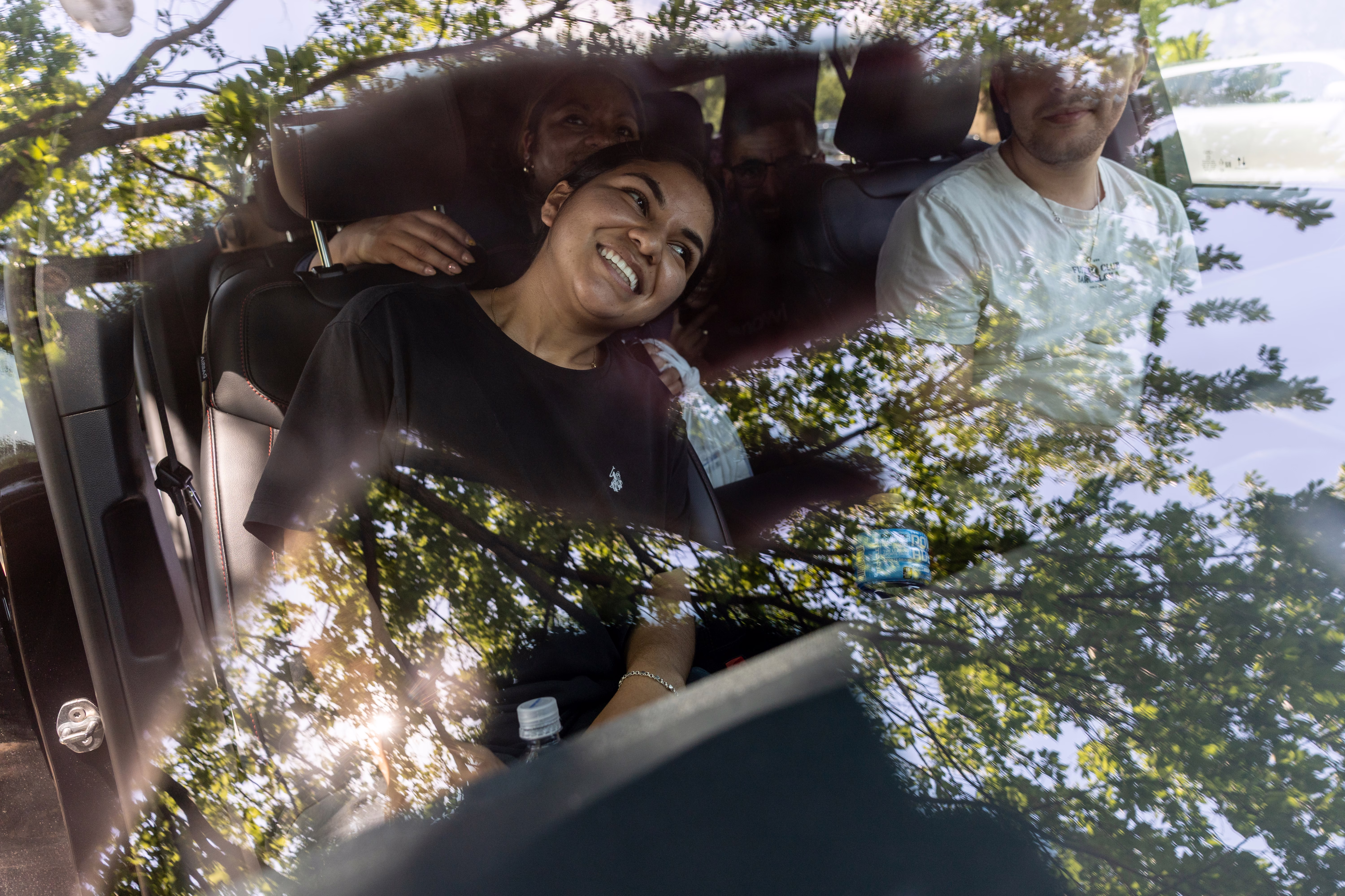 People smile and relax inside a car on a hot day.