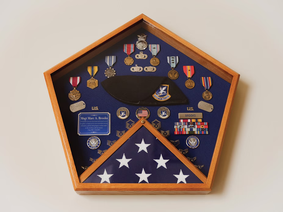 photo of pentagonal wooden shadowbox with medals and a triangular-folded U.S. flag at bottom
