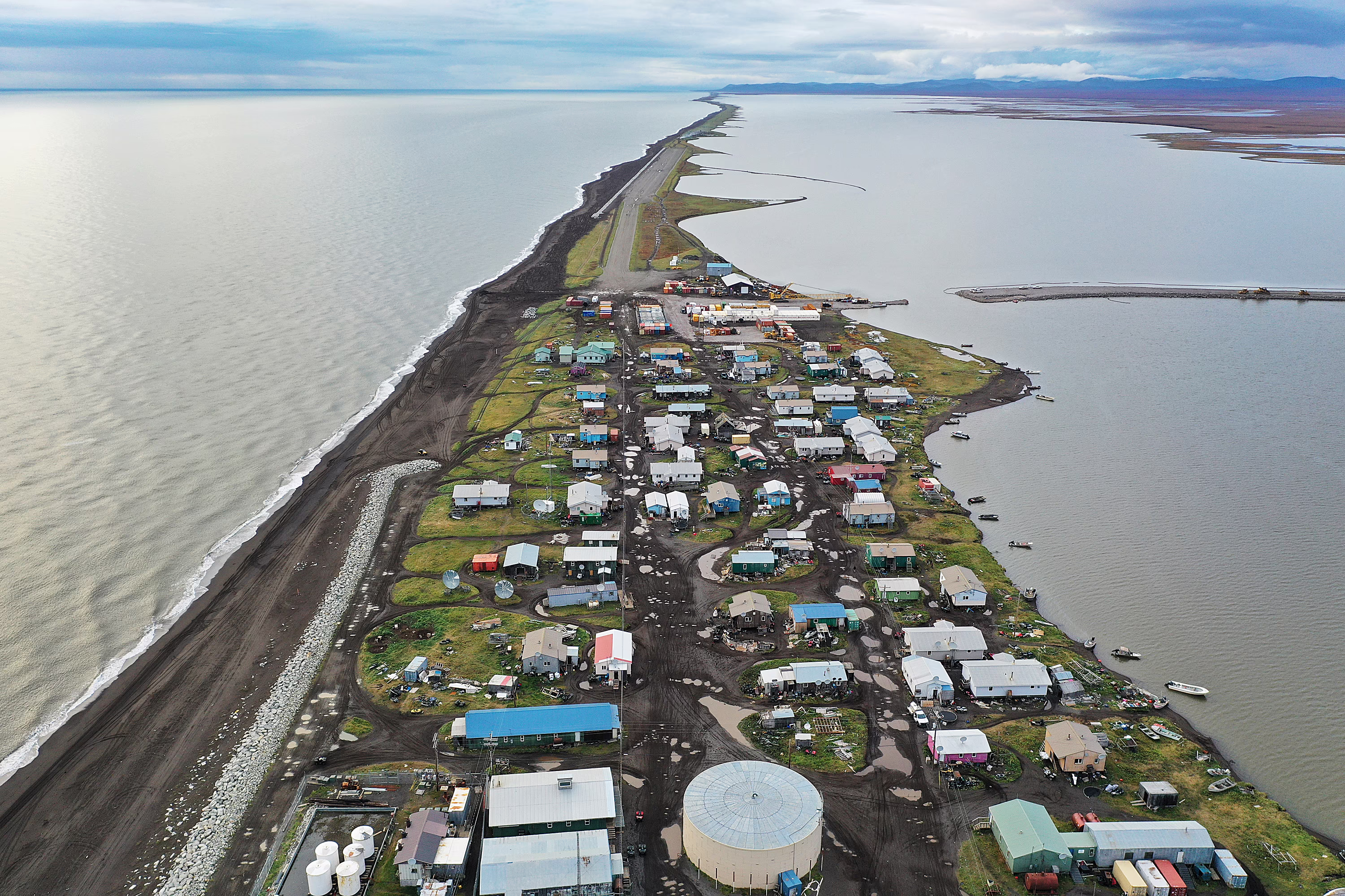 An aerial view of an Alaskan village on a long and narrow spit of land