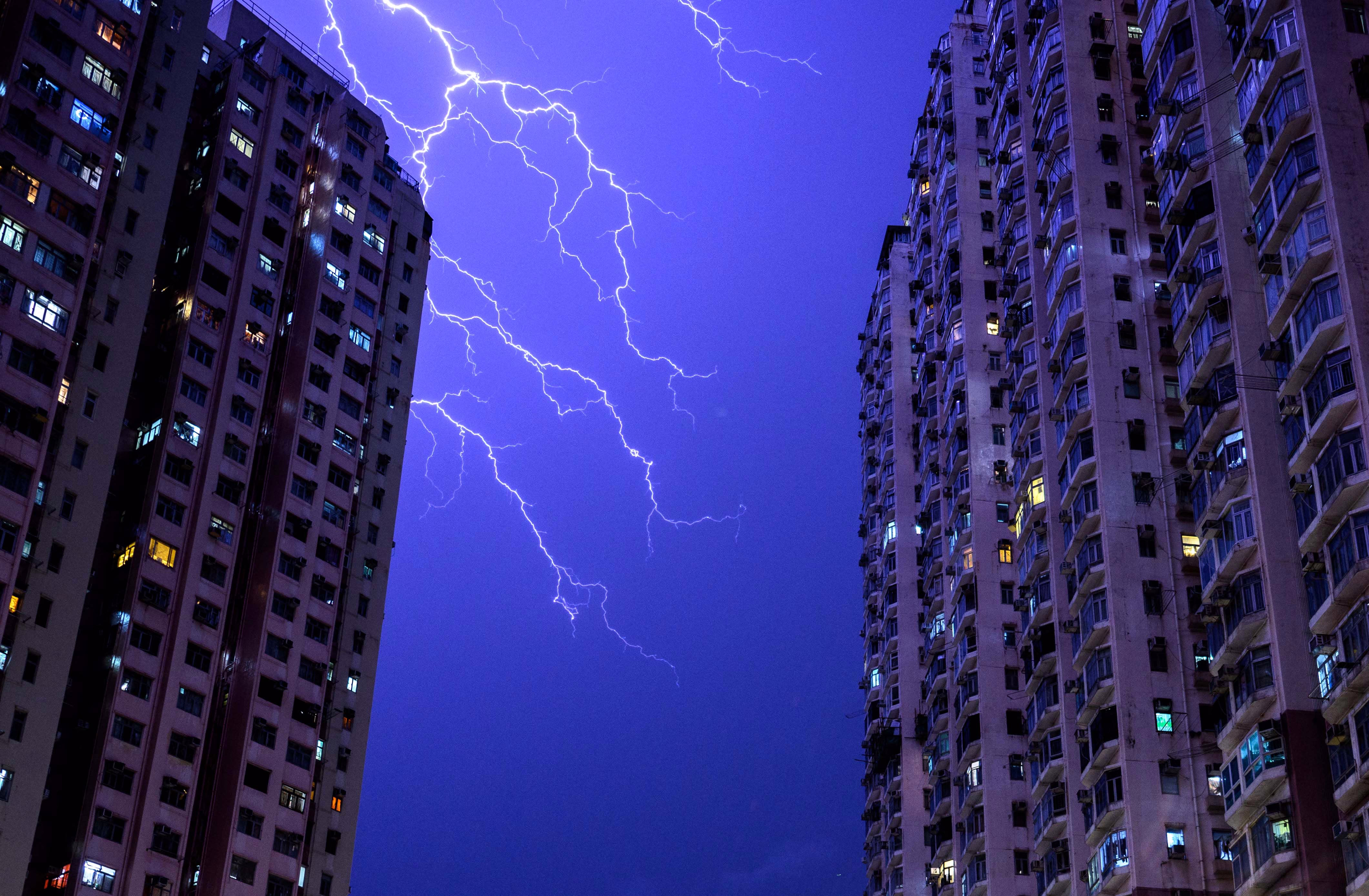 Lightning strikes above tall residential buildings.