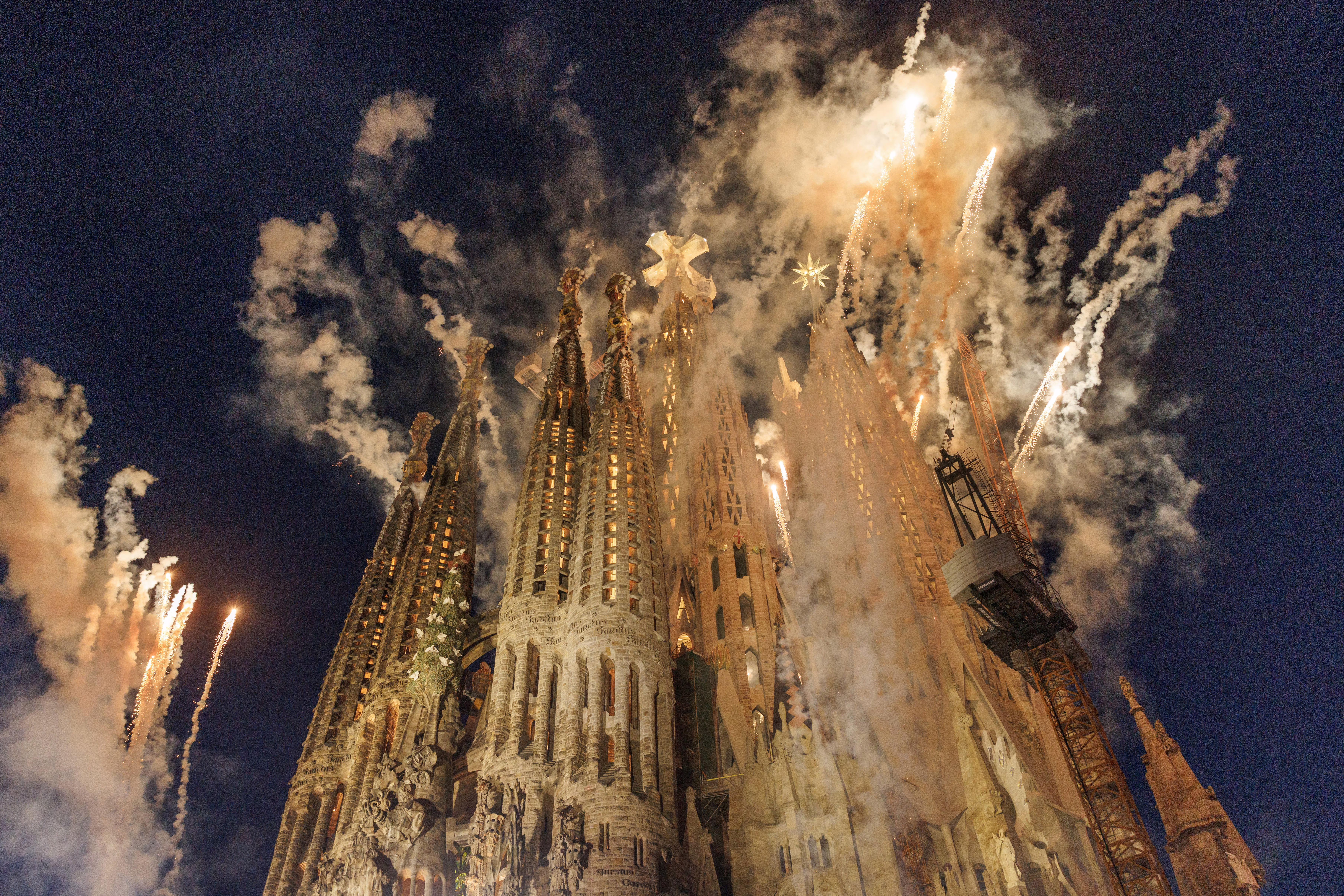 Smoke and fireworks erupt from the top of an ornate cathedral tower.