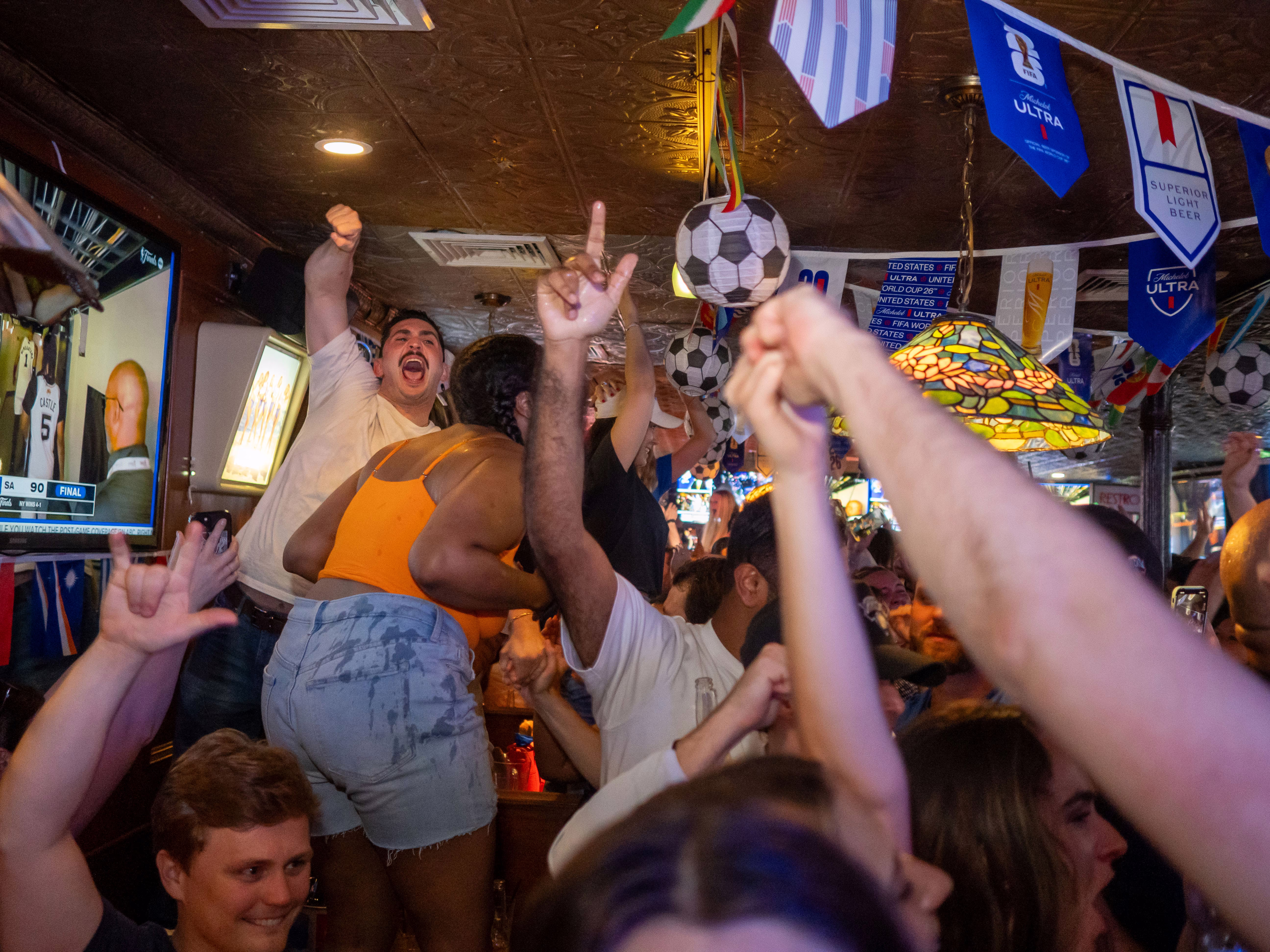Knicks fans erupt at a watch party in a bar.