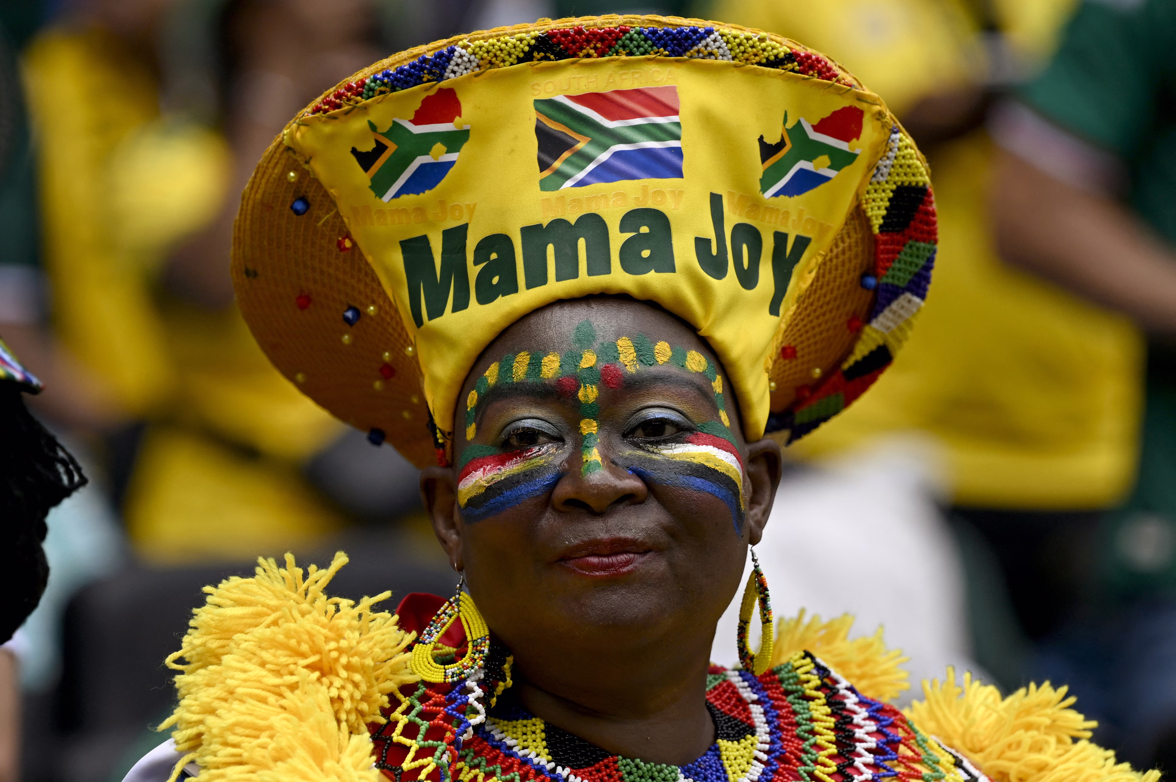 A fan of Team South Africa wears a costume including a tall hat that reads 'Mama Joy'.