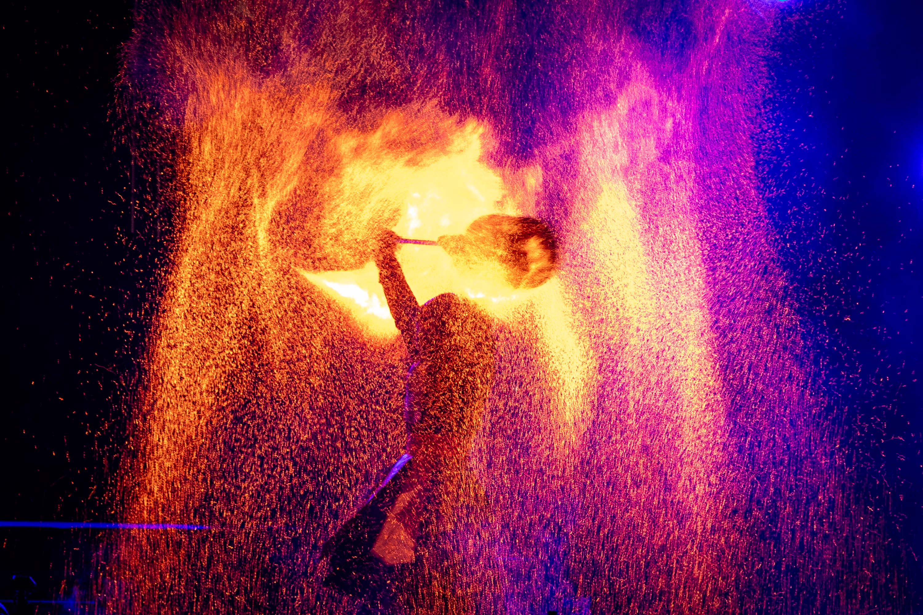 Sparks fly as a performer twirls a flaming object.