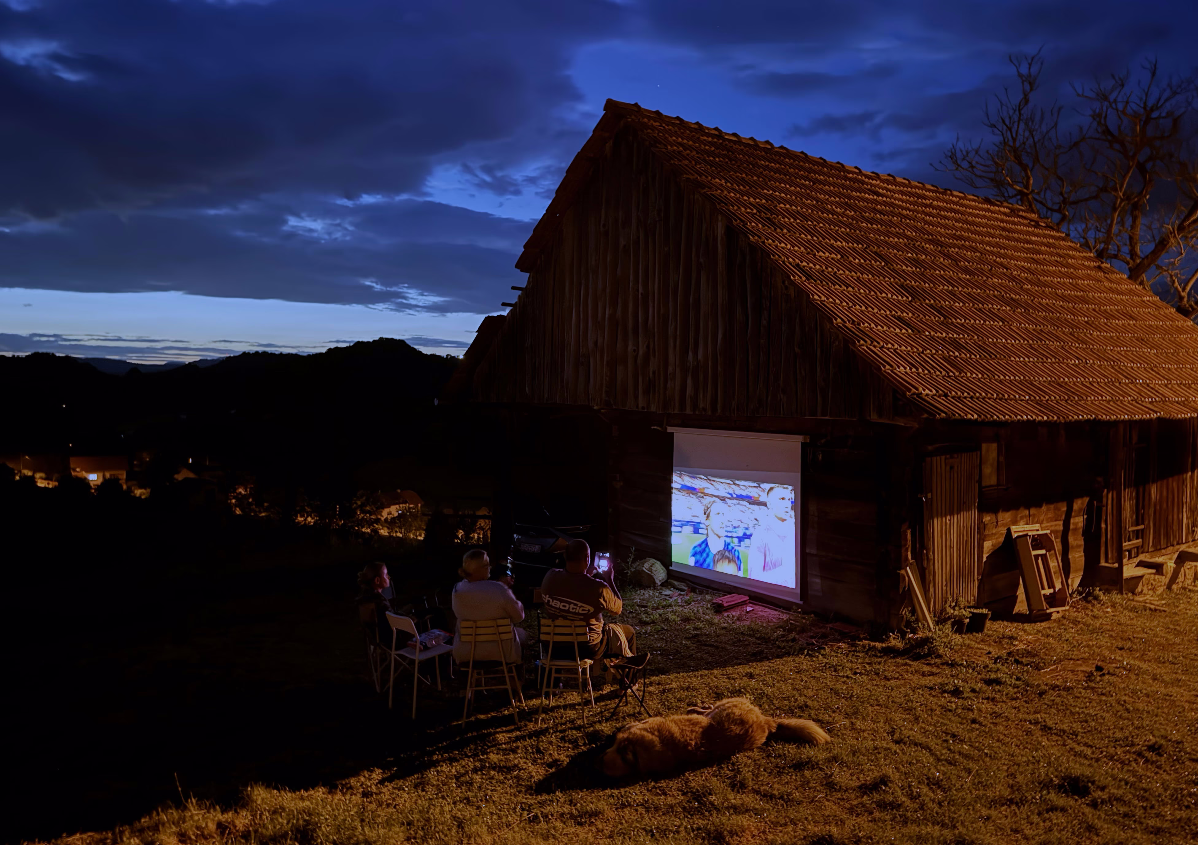 People watch a World Cup soccer match projected on a barn wall.