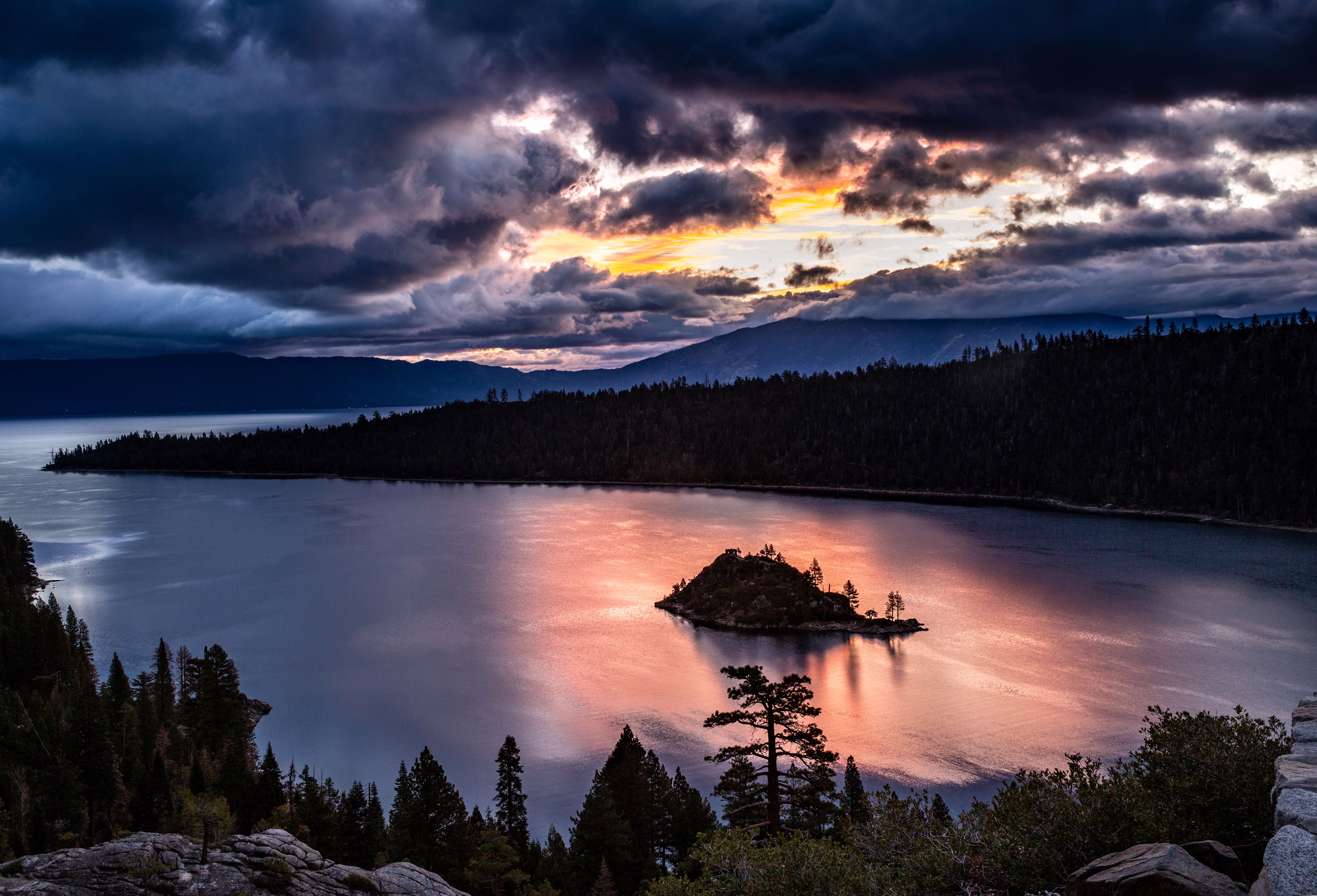 Sunrise on a cloudy day, seen over a mountain lake