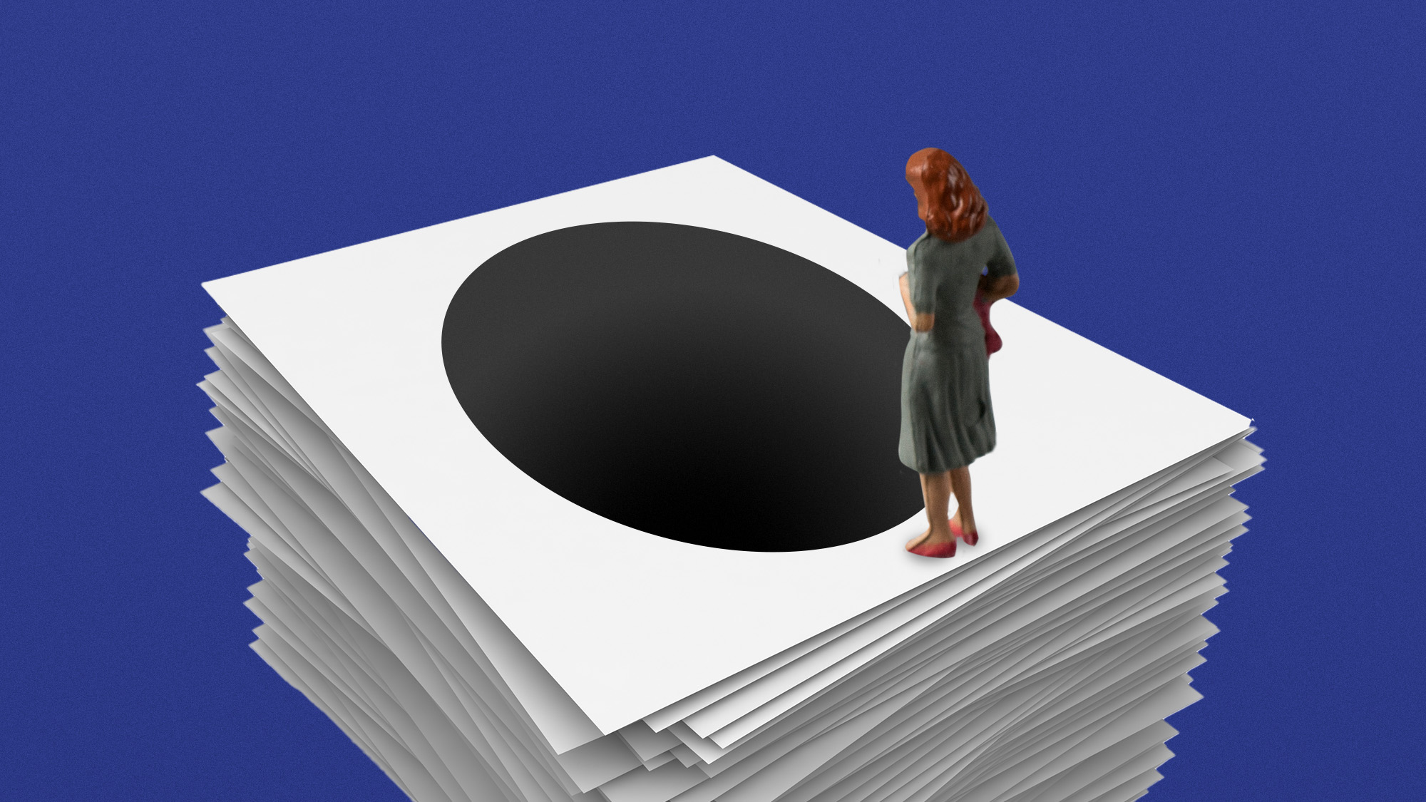 A woman stares down at a black hole going through a pile of documents