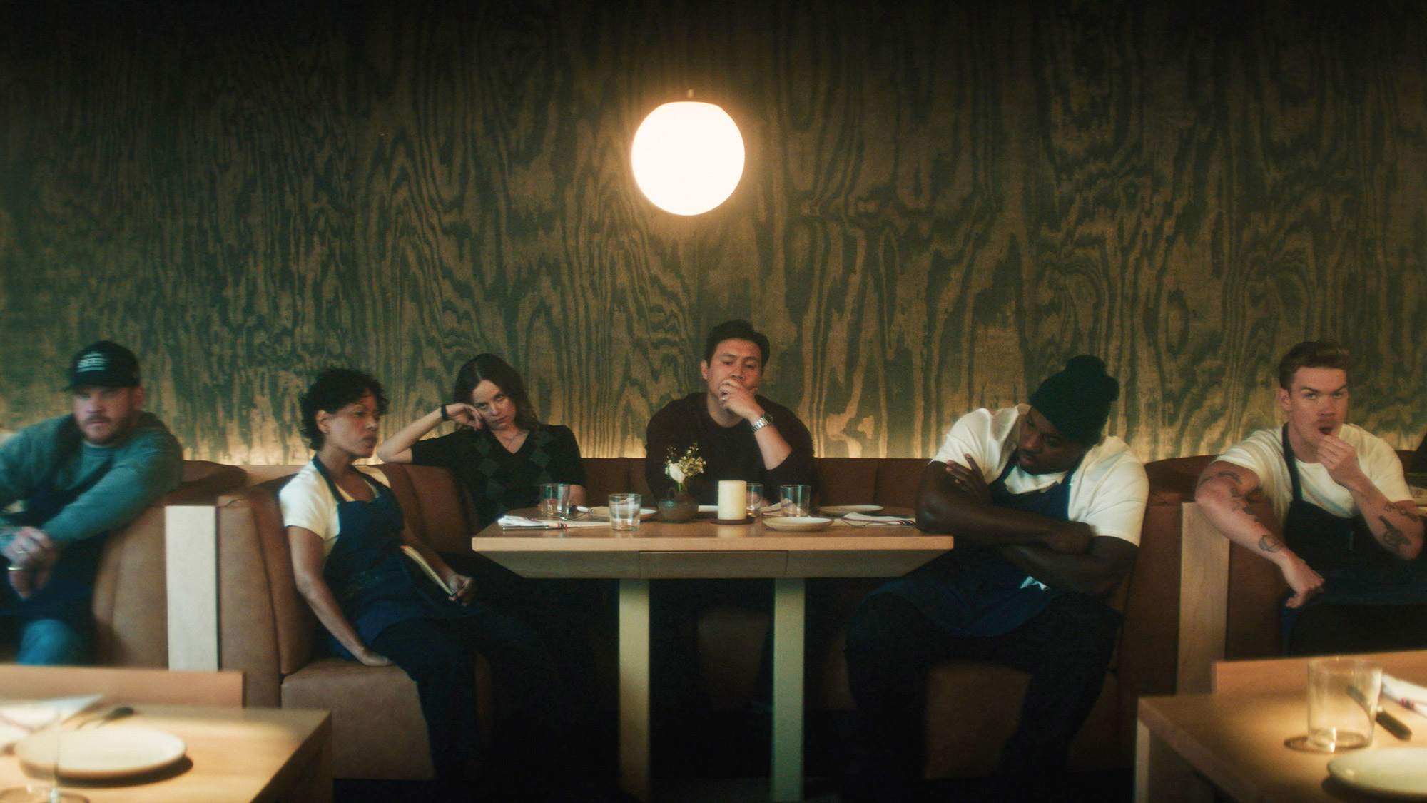 A still from The Bear, showing the workers sitting at booths in the restaurant
