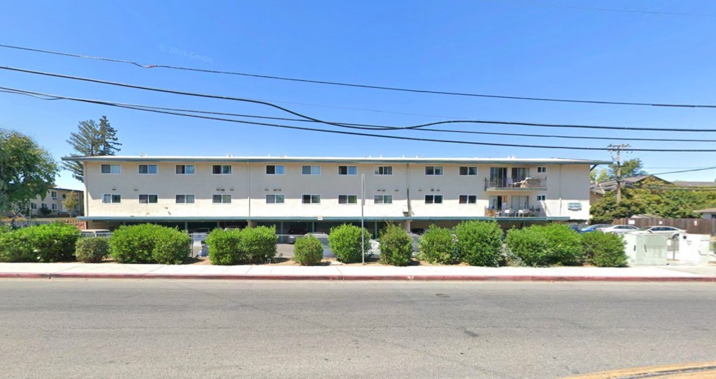 The 1900 block of California Street, featuring a multi-story apartment building with carports beneath, seen from across the street.