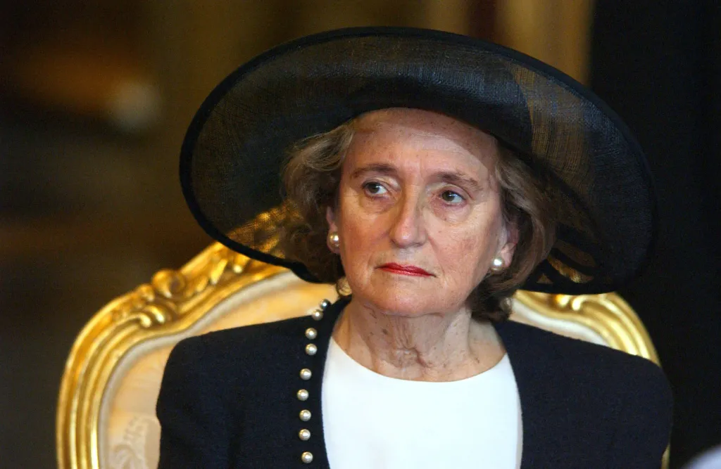Bernadette Chirac in a black hat, black jacket with pearl buttons, and white shirt.