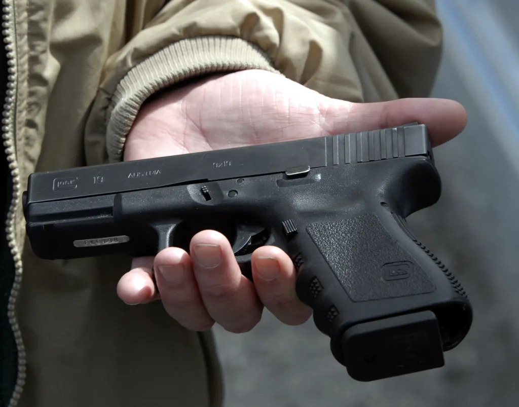 John Markell holds a Glock 9 mm pistol.
