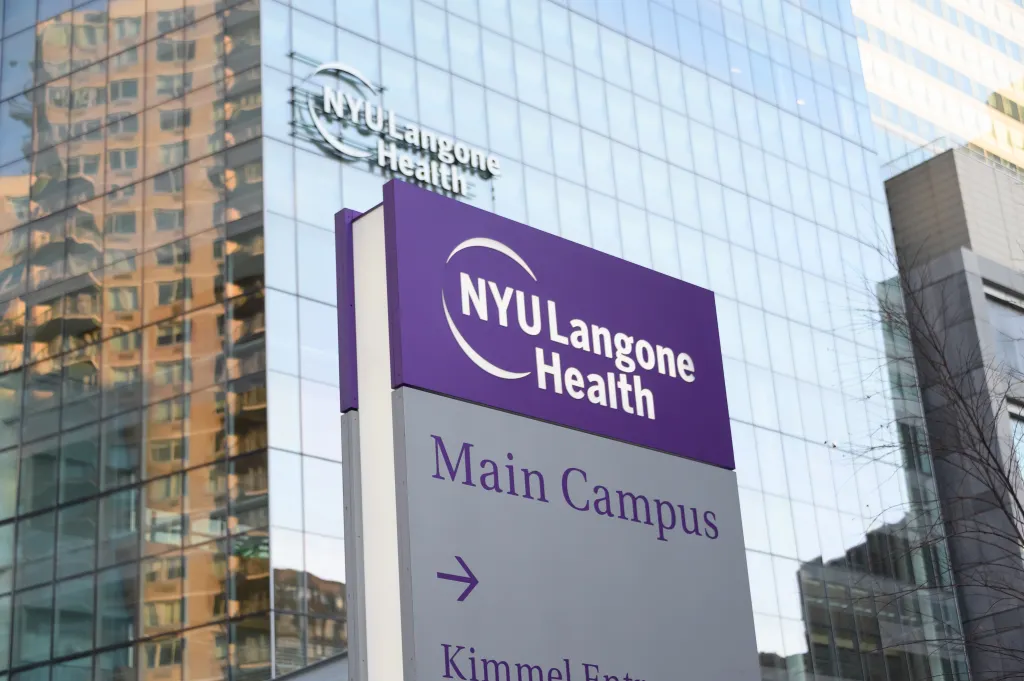 Sign for NYU Langone Health's Main Campus and Kimmel Entrance, with the hospital building in the background.