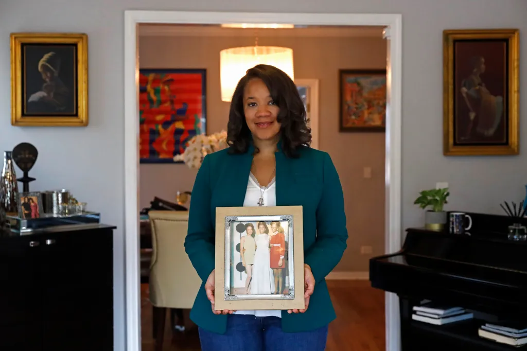 Robin Rue Simmons holding a photograph of her mother, aunt, and grandmother.