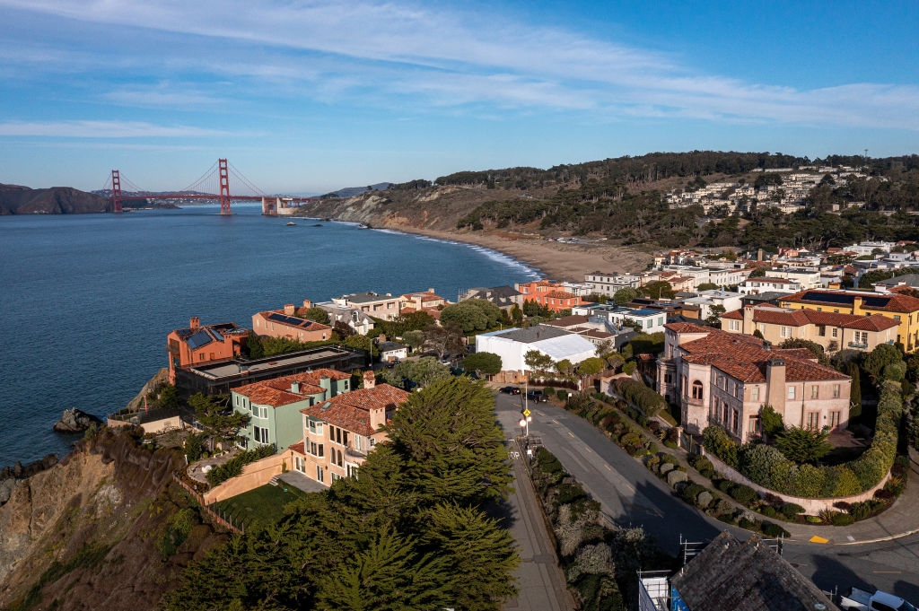 Aerial view of homes in the Sea Cliff neighborhood of San Francisco, California, with the Golden Gate Bridge in the background.