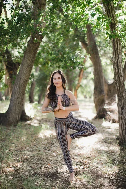 Ashley Phillips in a yoga tree pose in a forest.