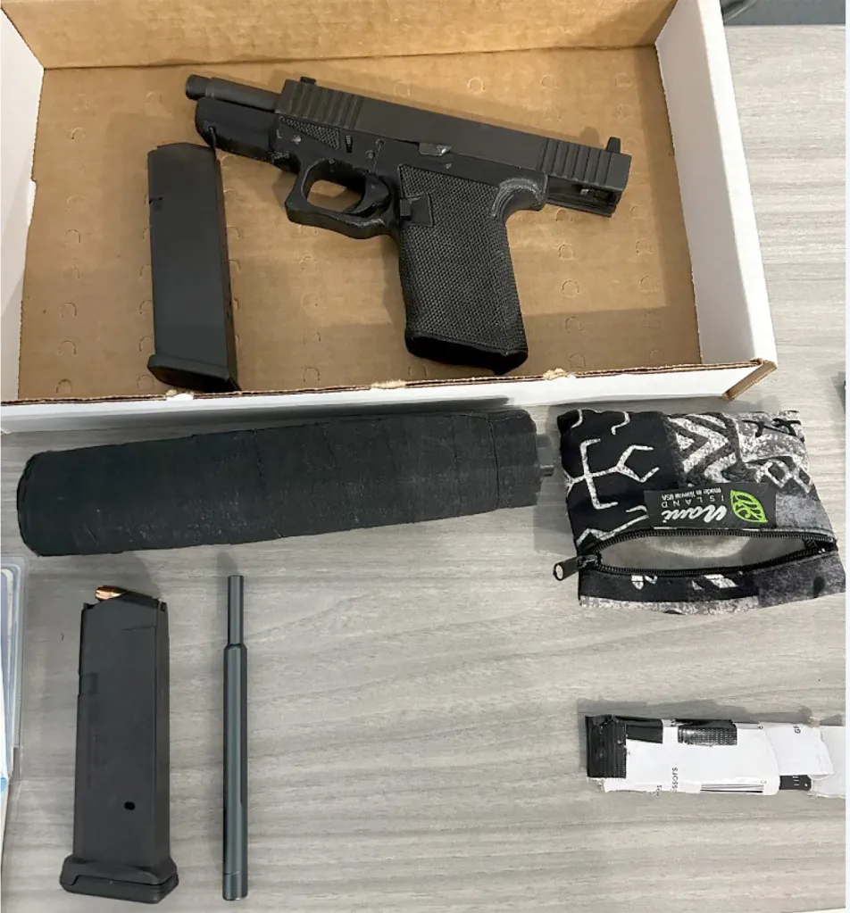 A black handgun with a silencer and magazines.