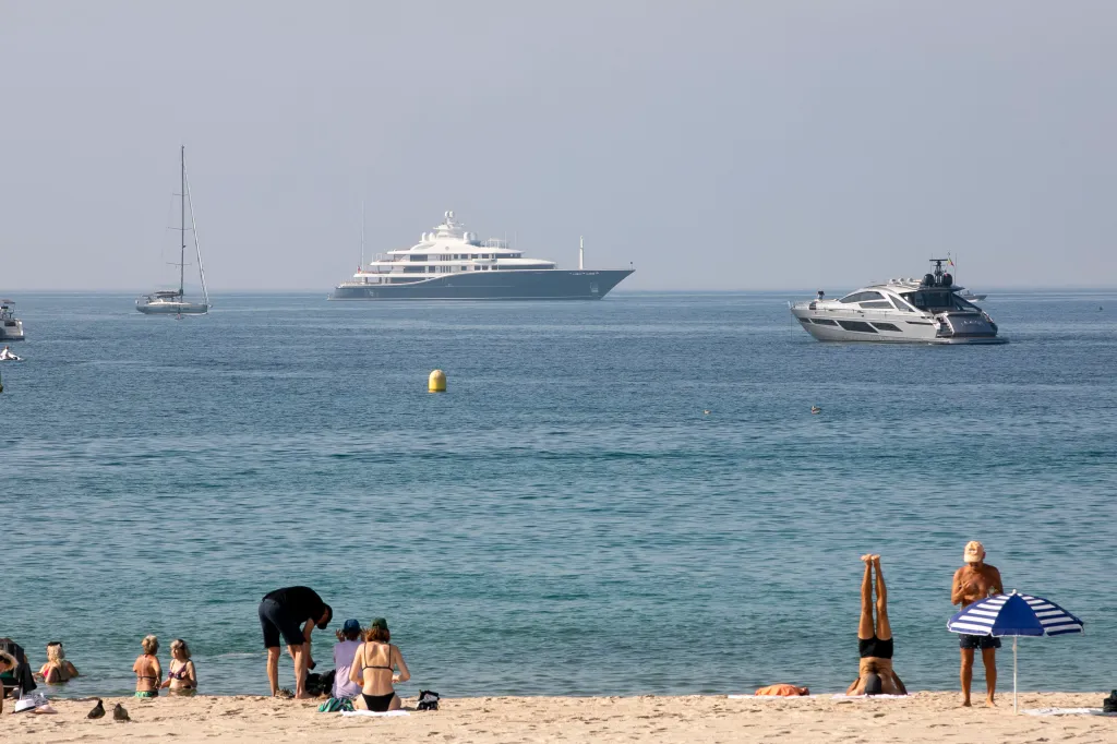 Yachts at sea during the Cannes Lions festival, with beachgoers in the foreground.