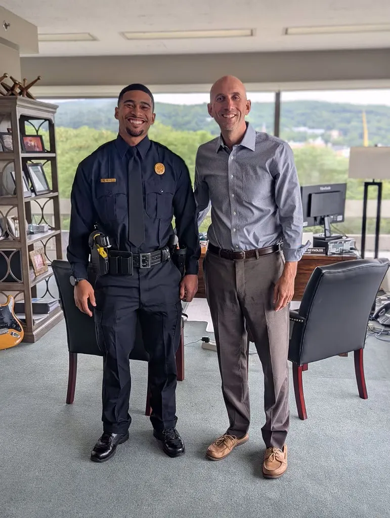 Officer Sean Reifel and Mayor Reynolds smiling at the camera after Reifel's swearing-in ceremony.