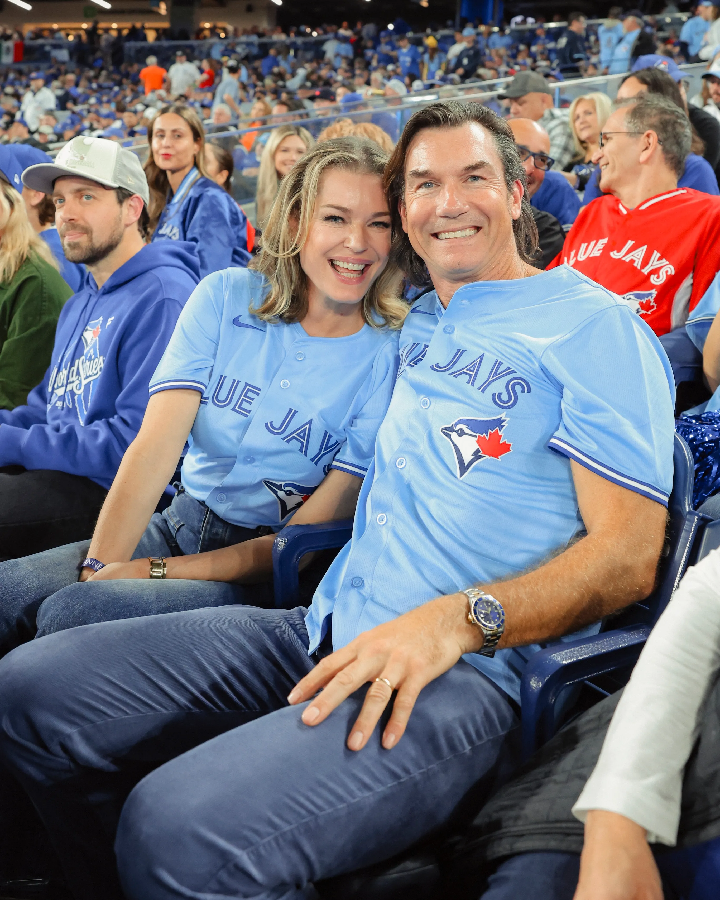 Rebecca Romijn and Jerry O'Connell wearing Toronto Blue Jays jerseys at a World Series game.