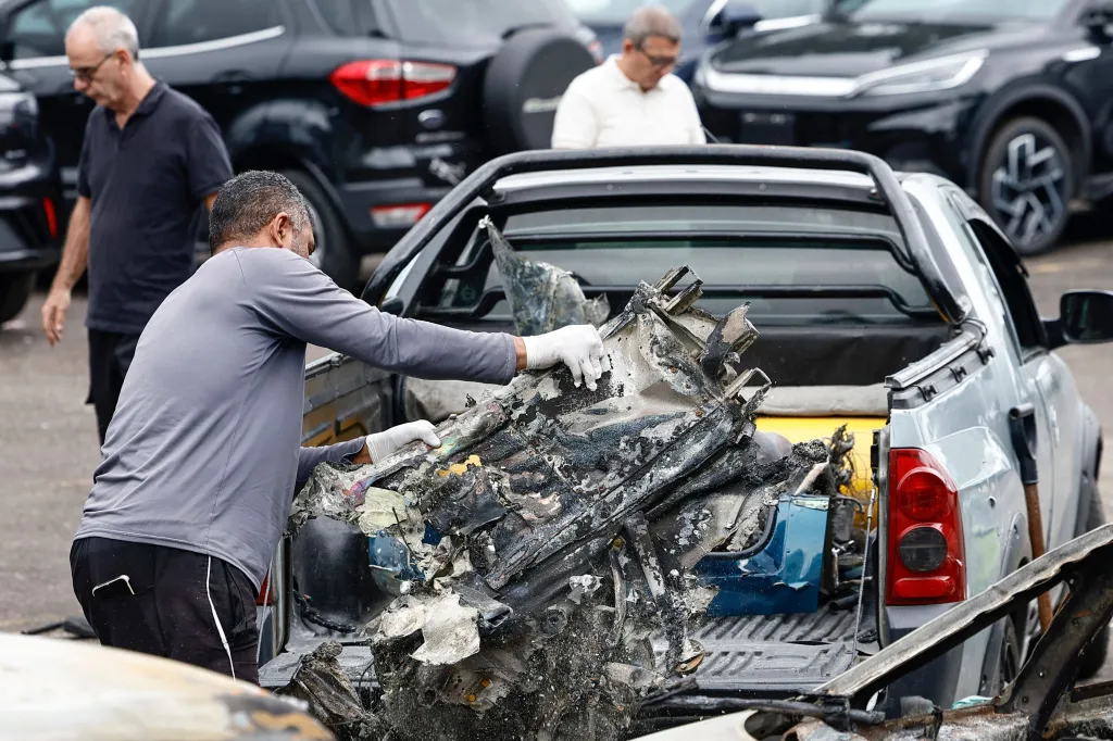 A technician handling debris from a helicopter crash in the back of a pickup truck.