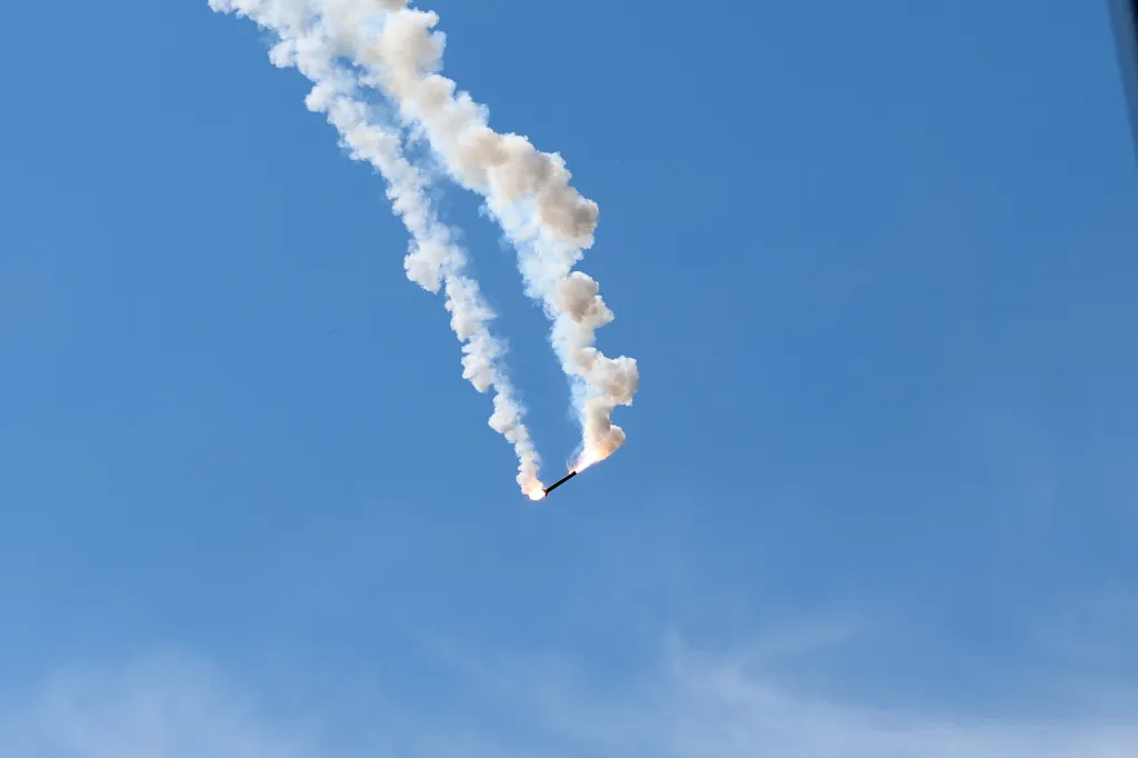 A bright light and smoke trail in a clear blue sky, indicating a failed air defense interception.