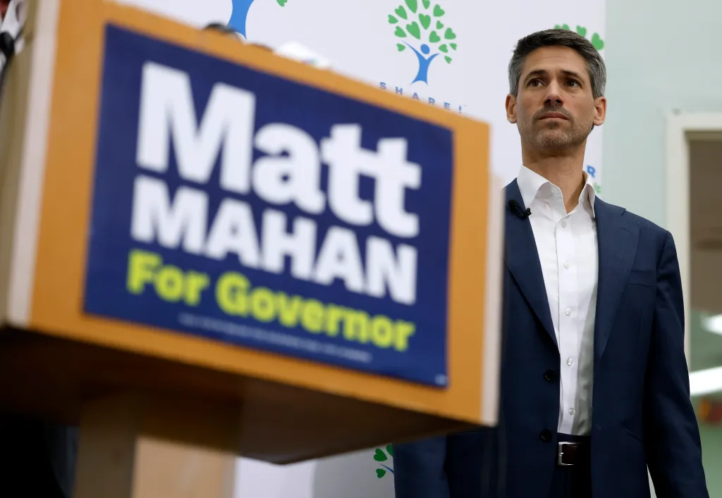 California Democratic gubernatorial candidate Matt Mahan looking up while standing near a podium with his campaign sign.