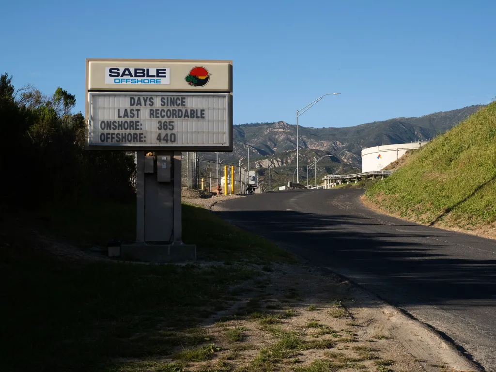 A sign for Sable Offshore's Las Flores Canyon facility, with mountains in the background.