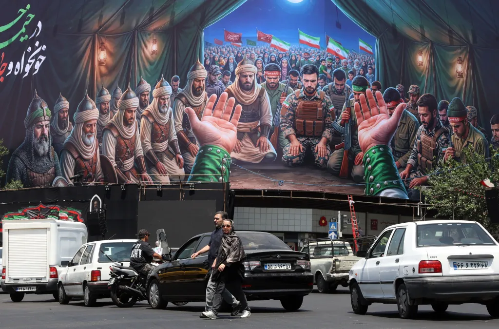 Iranians walk past a billboard at a public square in Tehran, Iran, on June 18, 2026.