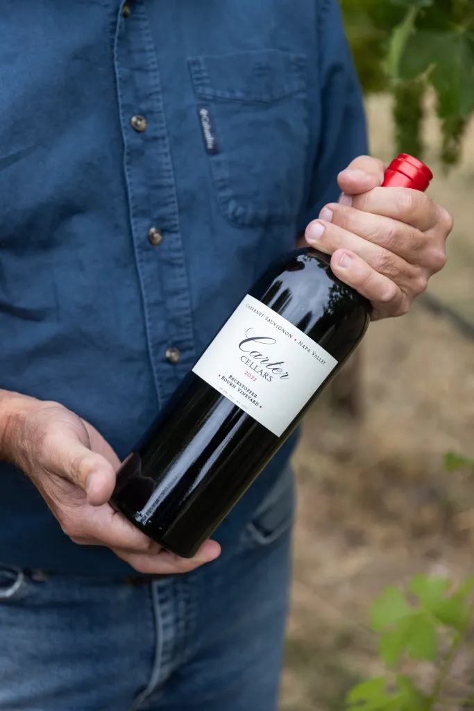 Jim Lincoln, Senior Vineyard and Environmental Sustainability Manager, holds a bottle of Carter Cellars Cabernet Sauvignon from Beckstoffer Vineyards.