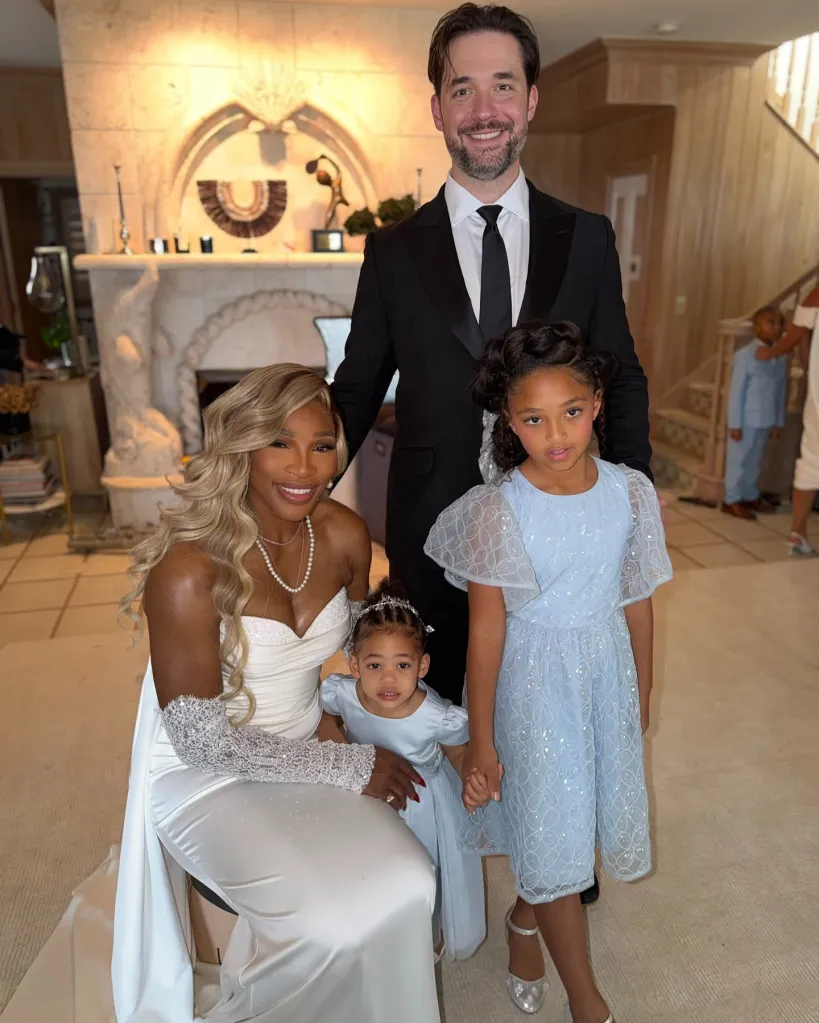 Serena Williams in a white gown with her husband and two daughters, all dressed up, in a home.