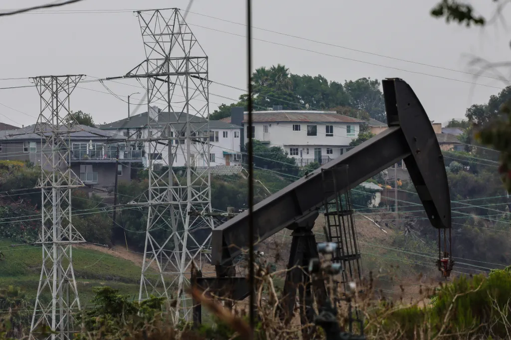 An oil rig in Windsor Hills, Los Angeles, with power lines and houses in the background.