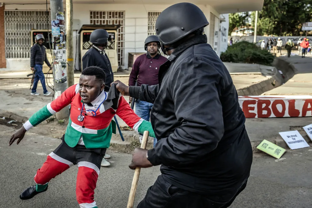 A Kenyan protester in a red, green, and white outfit with a stethoscope being arrested by plainclothes police.