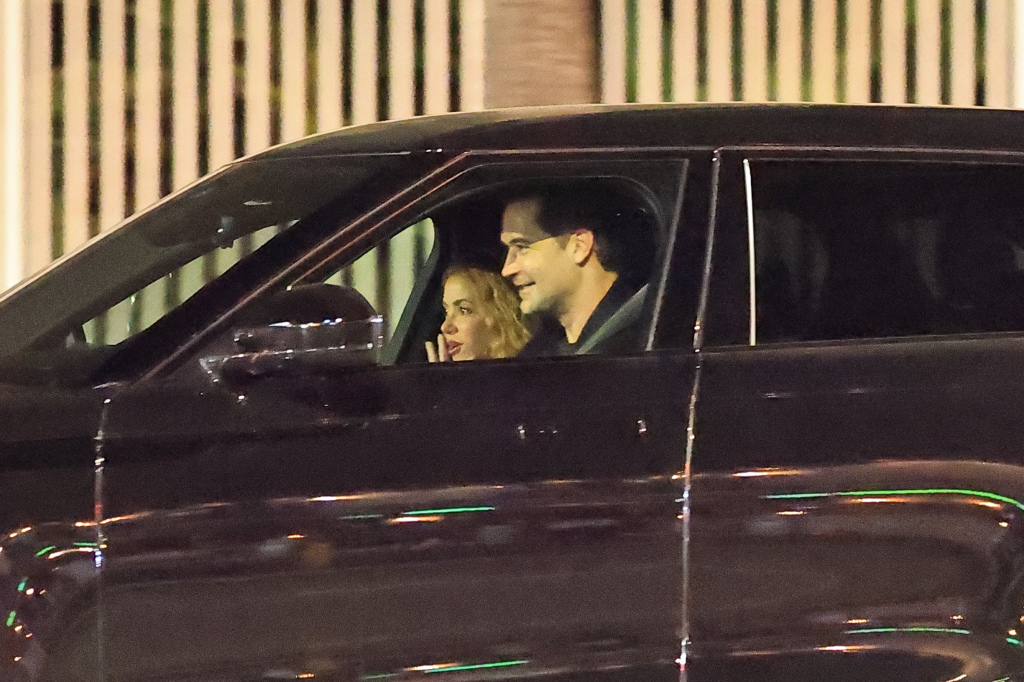 Shakira and Manuel Garcia smiling in a car.
