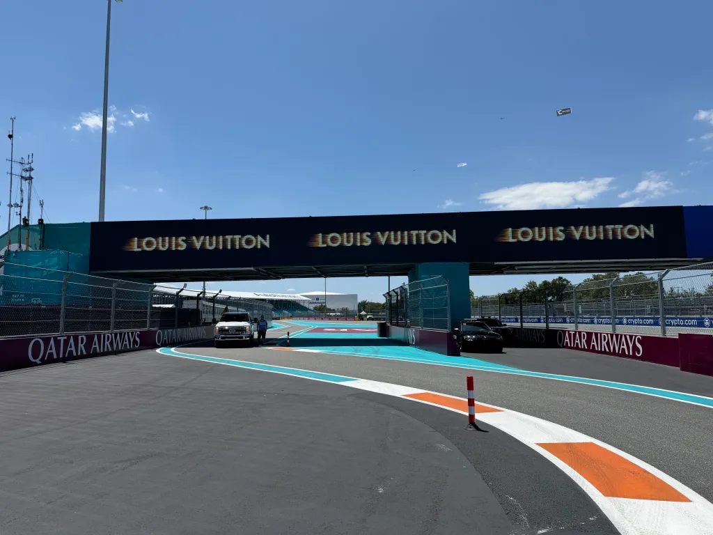 Formula 1 Miami Grand Prix track with a large Louis Vuitton banner overhead.