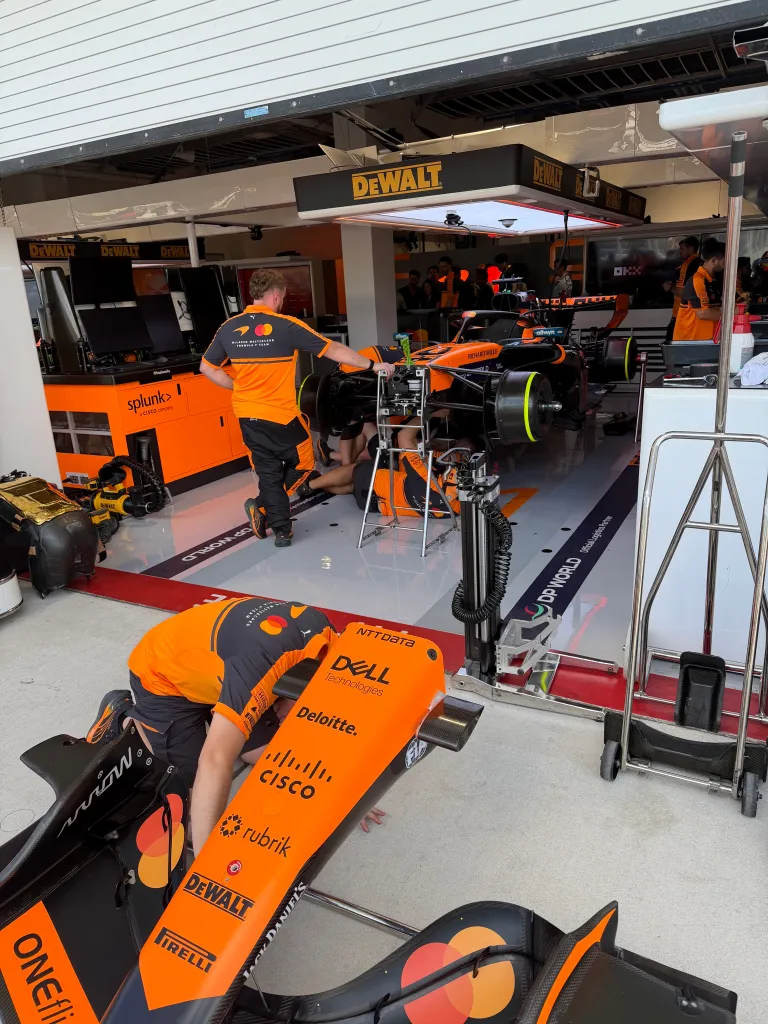 McLaren Formula 1 team mechanics working on a car in the garage during the Miami Grand Prix.