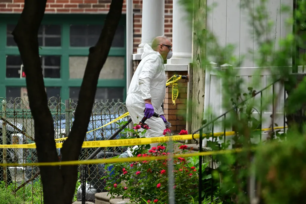 A man in a hazmat suit and mask investigating a crime scene.